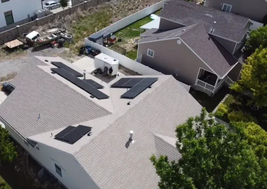 Drone view of a freshly installed architectural shingle roof with solar panels, completed by One Love Roofing